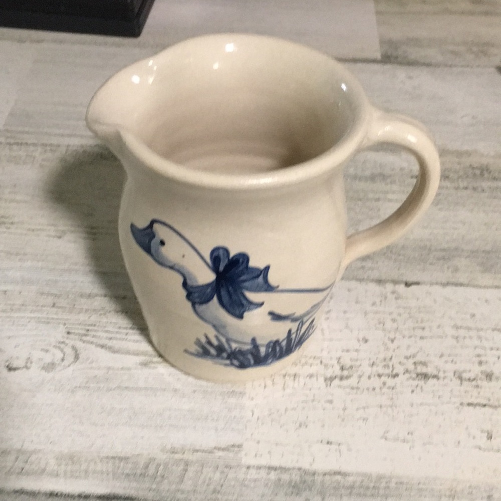 Small cream colored ceramic pottery pitcher with duck in blue with blue bow